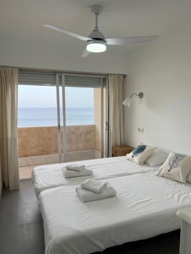 a bedroom with a large white bed with a view of the ocean at Ático dúplex en Playa Fossa Calpe in Calpe