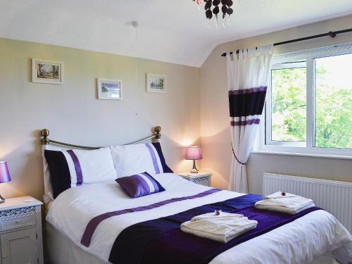 a bedroom with a bed with two towels on it at Glennydd in Bronant