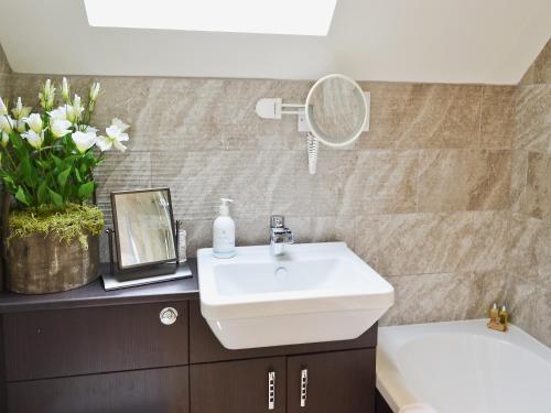 a bathroom with a white sink and a mirror at Waterside in Warkworth
