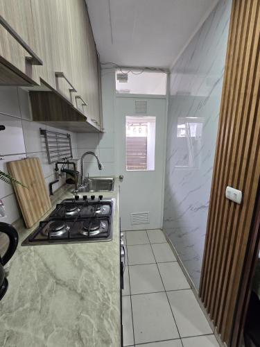 a kitchen with a stove and a counter top at Espacio moderno y acogedor departamento en Rancagua in Rancagua