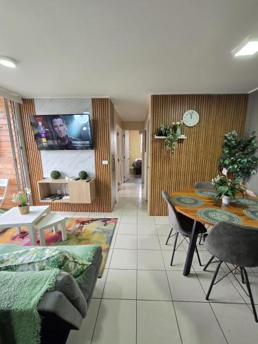 a living room with a couch and a table and a tv at Espacio moderno y acogedor departamento en Rancagua in Rancagua