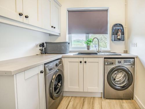 a kitchen with a washing machine and a sink at Cefn Gelli in Clynderwen