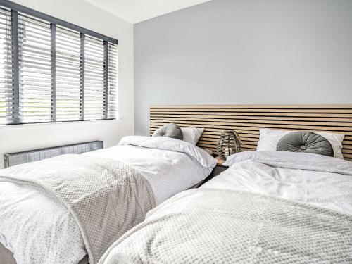 a bedroom with two beds with white sheets at Cefn Gelli in Clynderwen