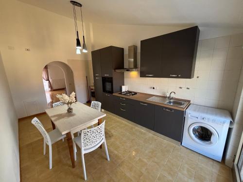 a kitchen with a table and a washing machine at Casa RoSi in Torrevecchia Teatina