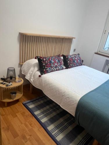 una camera da letto con un letto, un tavolo e una finestra di Apartamento SAN JUAN a Cudillero
