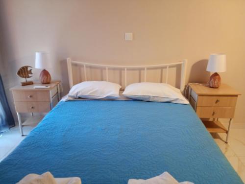 a bedroom with a blue bed with two night stands at Village House in Ágios Matthaíos