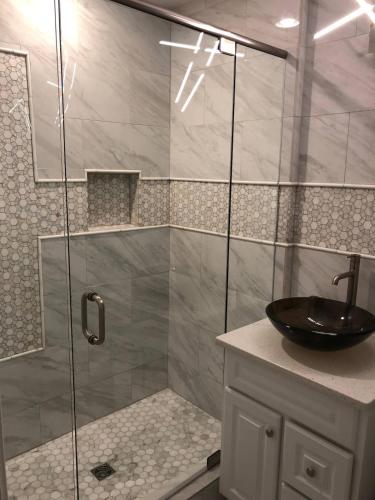 a bathroom with a glass shower with a sink at Cheerful 3-bedroom home in Newnan