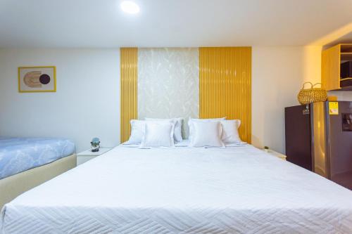 a bedroom with a large white bed with white pillows at Comuna Loft in Medellín