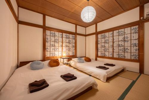 2 Betten in einem Zimmer mit Fenstern in der Unterkunft Lido Urayasu in Tokio