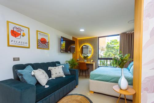 a living room with a blue couch and a bed at Comuna Loft in Medellín