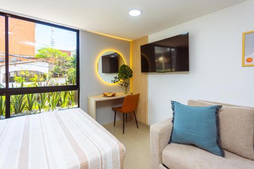 a bedroom with a bed and a chair and a window at Comuna Loft in Medellín