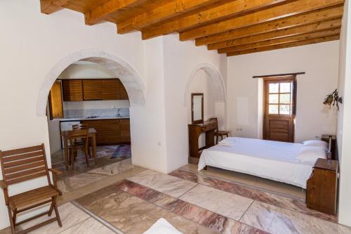 een slaapkamer met een bed, een tafel en een bureau bij Lithochtisto in Monemvasia