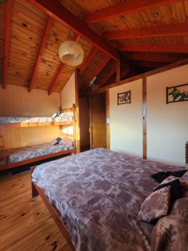 a bedroom with a large bed in a room with wooden ceilings at Cabañas Dulce Atardecer in Villa Carlos Paz