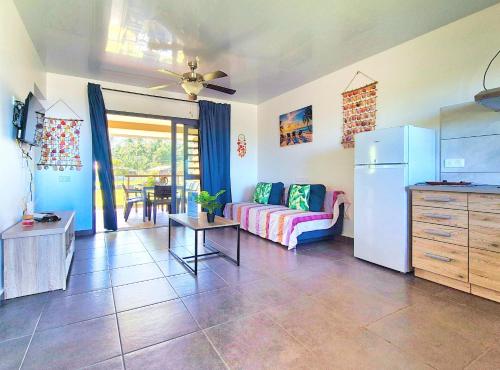 a living room with a couch and a refrigerator at Teahupo'o Lodge Tahiti - Fare Terre et Mer - climatisé - canoe et paddle in Teahupoo
