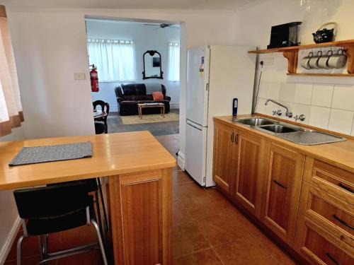 a kitchen with a sink and a refrigerator at Contemporary Studio Accommodation in Farrell Flat