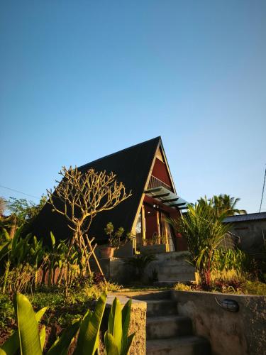 una casa con techo negro y algunas plantas en Casa Sundara, en Patjung