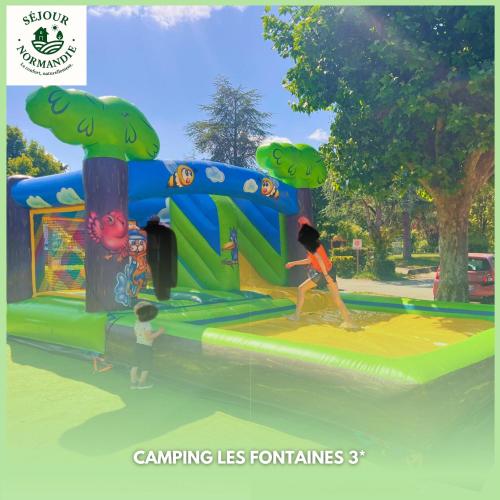 two children playing on a play structure at a park at Mobile home 6P XL Climatisation TV WIFI parcelle XXL au calme in Ivry-la-Bataille