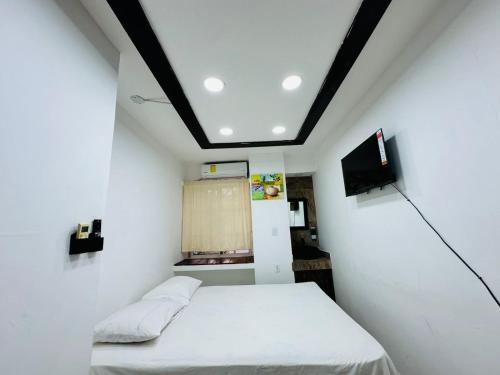 a small room with two beds and a tv at HappiCasaRD & Holistic House in Sosúa