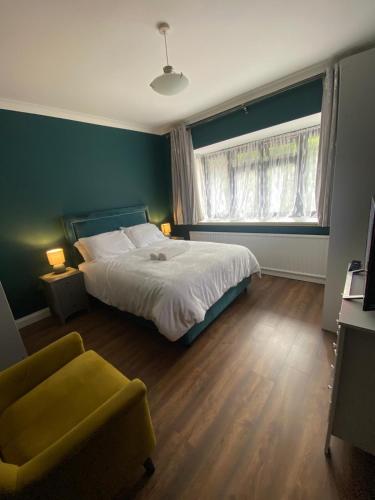 a bedroom with a bed and a chair and a window at Two double bedroom self contained Retreat in Thundersley