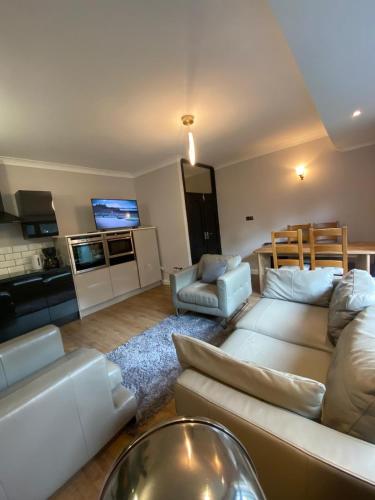 a living room with a couch and a tv at Two double bedroom self contained Retreat in Thundersley