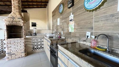 eine Küche mit Spüle und Steinofen in der Unterkunft The Férias | Suites Praia in Cabo Frio