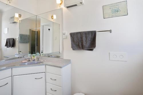 a bathroom with a sink and a mirror at Le Solterre - Akaroa Holiday Home in Akaroa