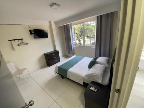a hotel room with a bed and a window at Hotel Avei Suites in Cali