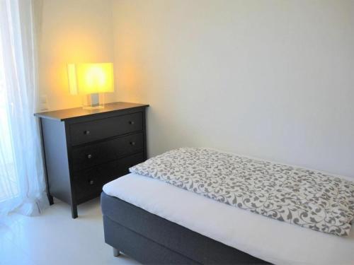a bedroom with a bed and a lamp on a dresser at Residence Golf Parco in Ascona