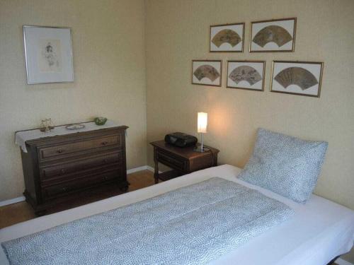 a bedroom with a bed and a table with a lamp at 1-bedroom holiday home in Ponte Brolla