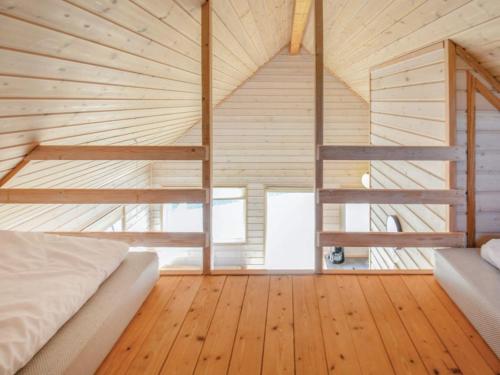 Thyborønにある4 star holiday home in Thyborønのベッドと木の床のある寝室