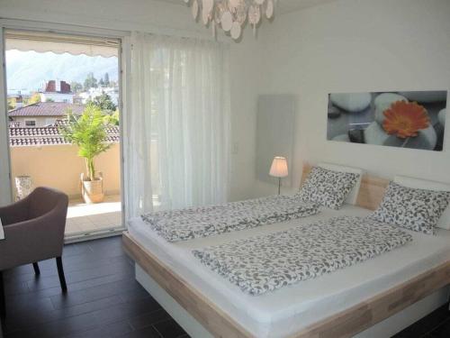 una cama en una habitación con una ventana grande en 1-bedroom apartment, en Ascona