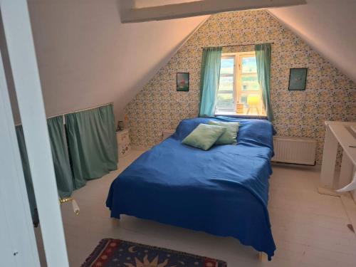 Un dormitorio con una cama azul y una ventana. en 5 person holiday home in Lundby, en Lundby