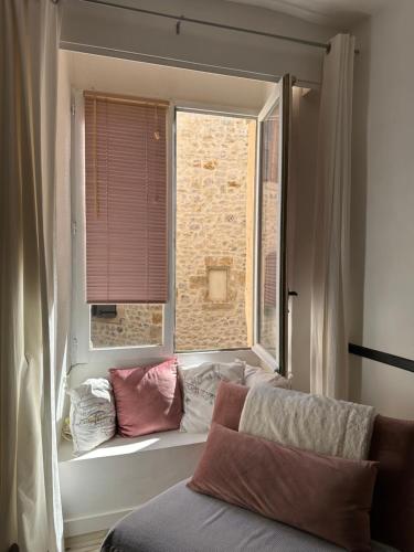 a window with pillows sitting on a window sill at Gîtes Lavande et Jasmin 3 étoiles in Anduze