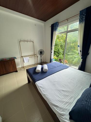 a bedroom with a large bed and a window at Seetha Homestay Kandy in Kandy