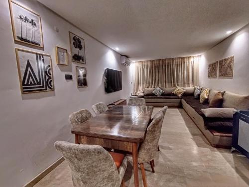 a living room with a table and a couch at Appartement Imi ouaddar Bord de mer acces direct plage in Imi Ouaddar
