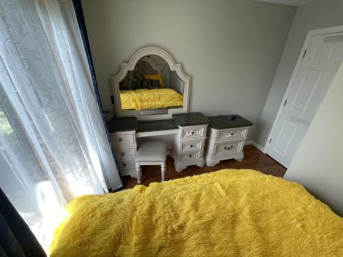 a bedroom with a bed and a mirror and a yellow blanket at Charming 1-bdrm Apt close to all in Hamburg
