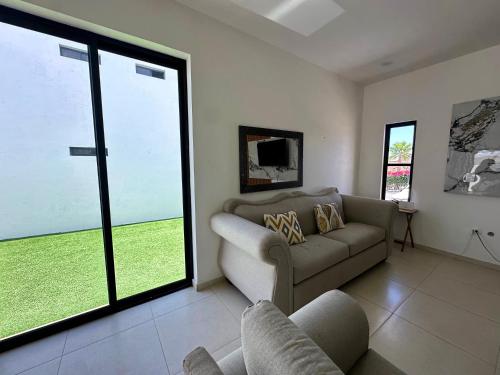 a living room with a couch and a large window at Casa SOLÉA San Carlos in San Carlos