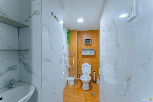 a bathroom with a white toilet and a sink at Ideal place to stay for 8-12pax with Parking Area in Mactan Island