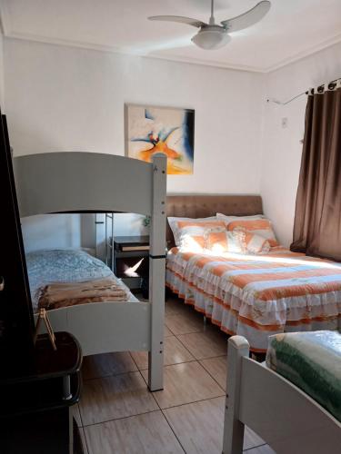 Un dormitorio con dos literas y un ventilador de techo. en Edicula com um quarto banheiro e piscina e lazer, en Foz do Iguaçu