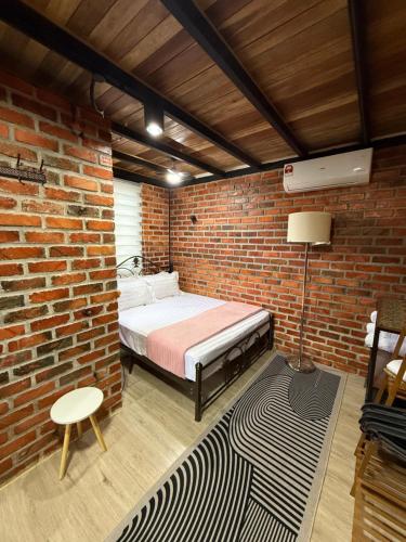 a bedroom with a bed in a brick wall at The Lil Luxe Tiny Homes Bangi - 2 Villa with 2 Private Pools in Bandar Baru Bangi