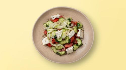 a bowl with a salad of vegetables and cheese at Mulaj Hotel in Tirana