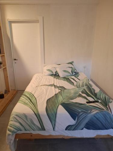 a bedroom with a bed with a blanket with leaves at peace&love in Eilat