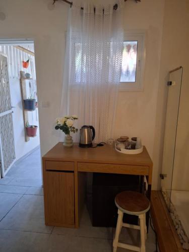 a wooden desk with a pot on it next to a window at peace&love in Eilat