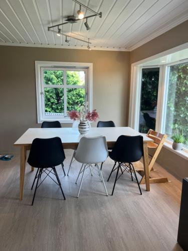 a dining room with a white table and chairs at Sentral enebolig på Lura med Jacuzzi! in Stavanger