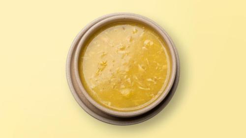 a bowl of yellow sauce on a white table at Mulaj Hotel in Tirana