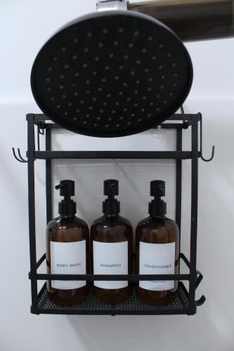a shelf with three bottles of soap on it at The Lake Barndominium in Delton