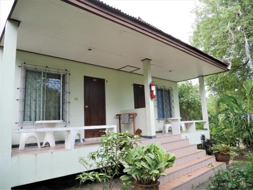 a white house with a porch and stairs at Floral House in Lamai
