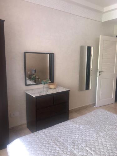 a bedroom with a dresser with a mirror and a bed at Playa Del Pacha, marina smir in M'diq