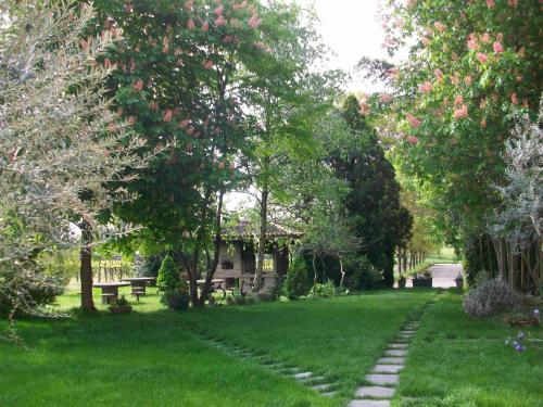 a garden with a path in the grass with a bench at Agriturismo Radaméz in Monzambano