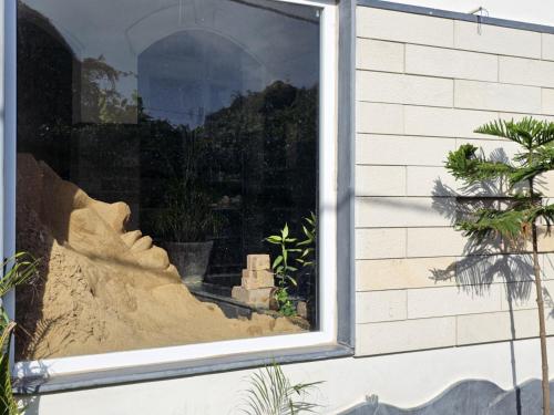 a window of a house with a pile of sand at NIRMAN HOMESTAY 5 minutes walk to beach in Puri